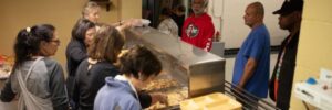Volunteers serve food to the needy.